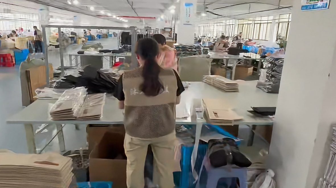 Production floor — workers staging finished boxes for reinforcement, inline QC, and master-carton packing